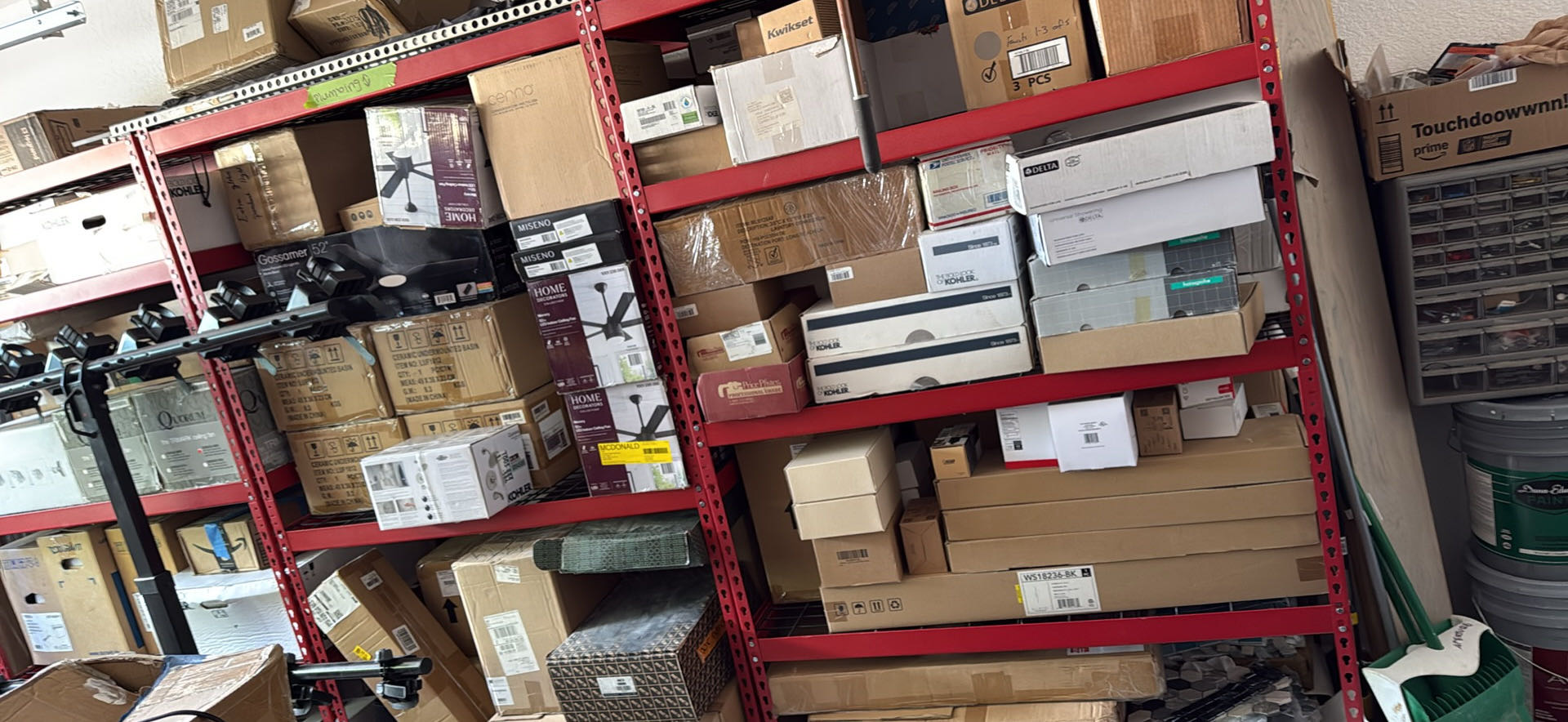 While garage full of house fixtures. Fans, tile, faucets, kitchen sinks, bathroom sinks, bathroom hardware, handles, mostly unopened 